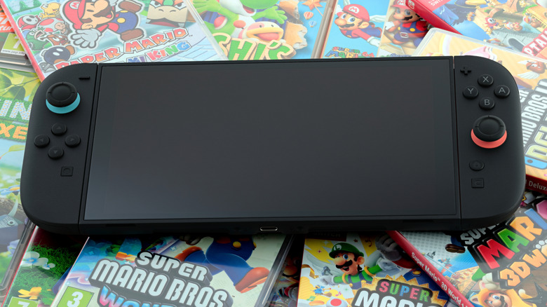 Nintendo Switch 2 lying on boxed retail Nintendo Switch 1 games