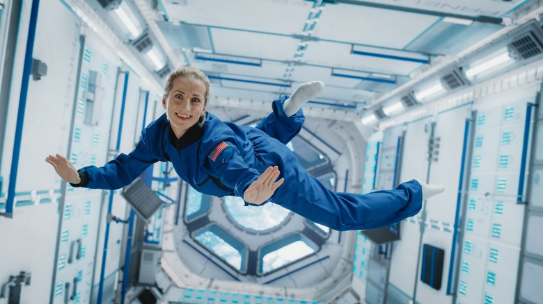 Astronaut floating inside spacecraft