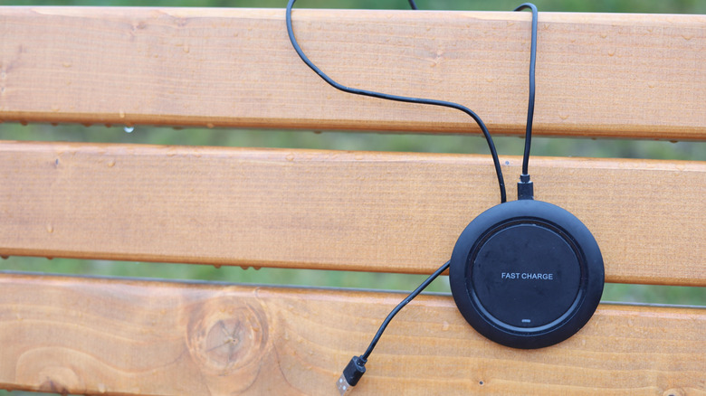A wireless charger hanging on a park bench