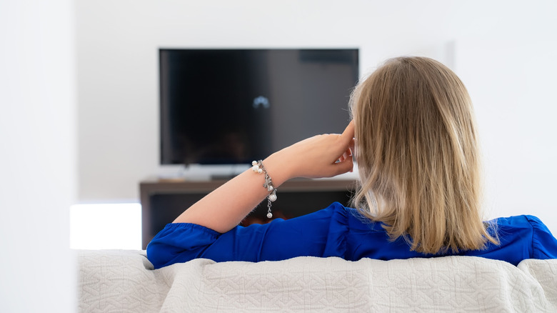 A person waiting for a TV to load that's stuck buffering