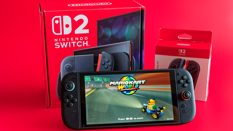 Nintendo Switch 2 in front of its packaging against a red background