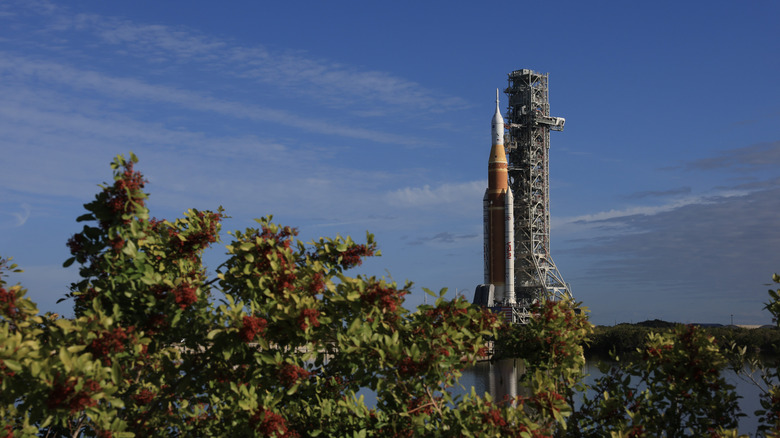 NASA's artemis II standing alongside the launch platform at kennedy space center