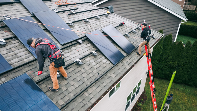 Workers installing solar panels on a residential roof
