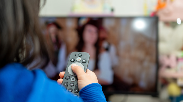 A child holding a smart TV remote.