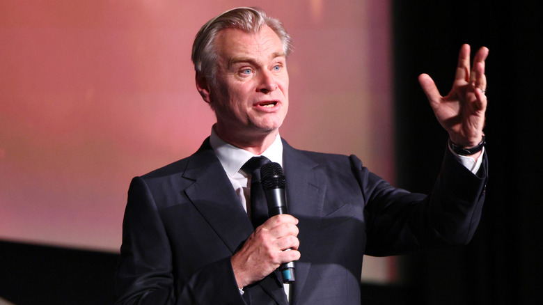 Christopher Nolan speaking into a microphone on stage
