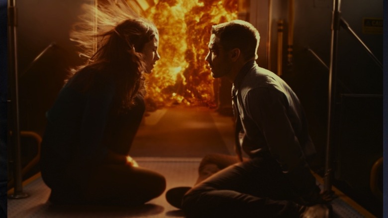 Jake Gyllenhaal and Michelle Monaghan kneeling near an explosion in Source Code