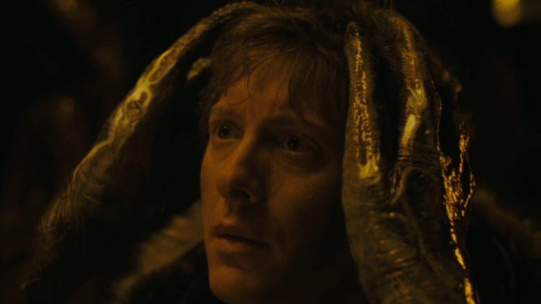 An alien grabbing Julian (James Spader) in 