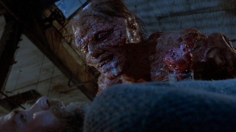 Seth Brundle (Jeff Goldblum) leaning over Stathis Borans (John Getz) in The Fly