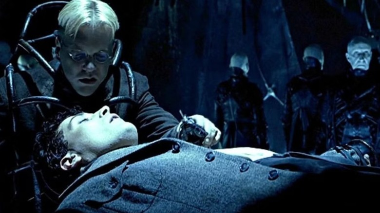 Dr. Daniel P. Schreber (Kiefer Sutherland) leaning over John (Rufus Sewell) in "Dark City."