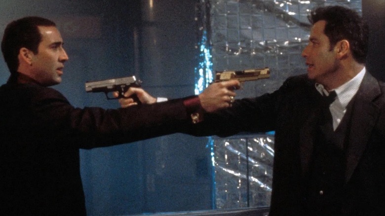 Nicolas Cage and John Travolta pointing guns at each other in Face/Off