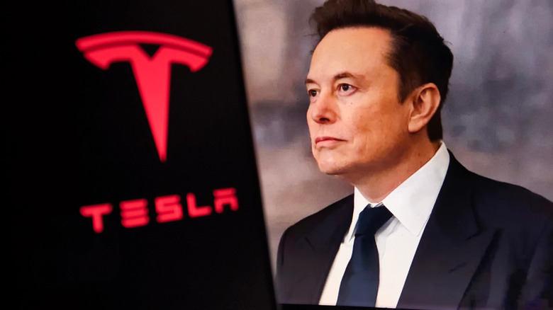 Elon Musk in front of a Tesla logo
