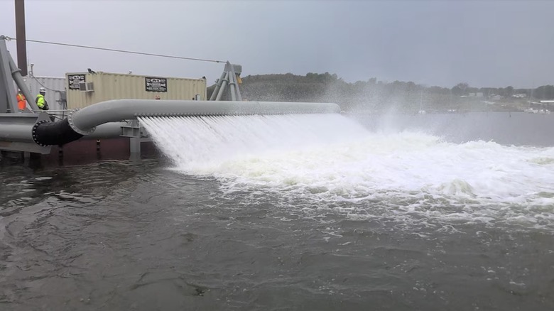 Barge spraying jets of water into lake