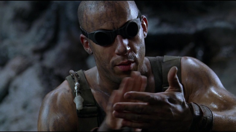 Riddick (Vin Diesel) looking at his hands in 