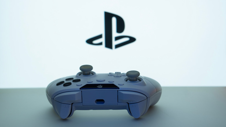 A controller on a table in front of the PlayStation logo.