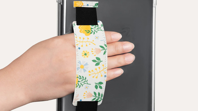 E-reader with handstrap and a person's hand in it