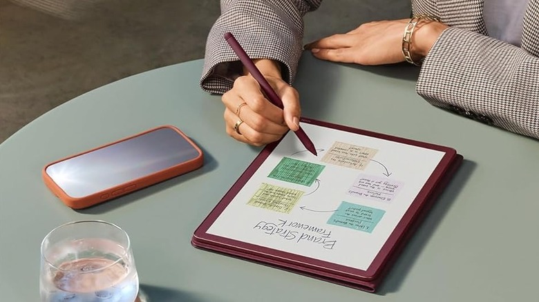 A woman taking notes on a Kindle Scribe Colorsoft.