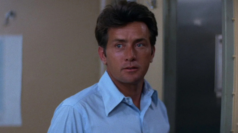 Warren Lasky (Martin Sheen) looking at something in 