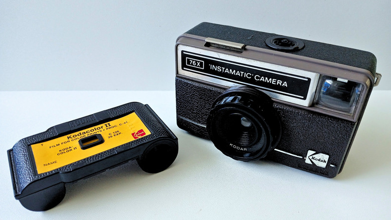 A Kodak Instamatic point-and-shoot camera next to a Kodak film cartridge.