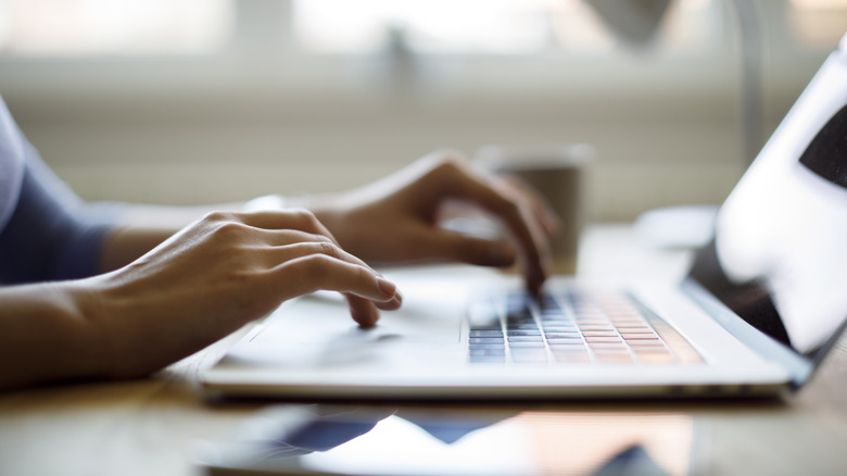 a person typing on a laptop
