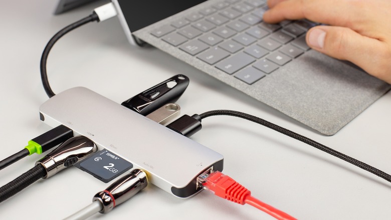 A USB-C hub adapter connected to to small laptop with multiple peripherals connected