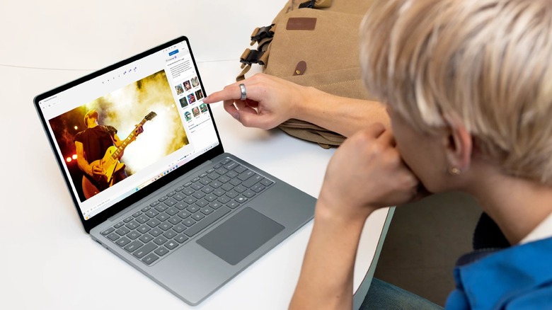A person using a Microsoft Surface touchscreen on a desk