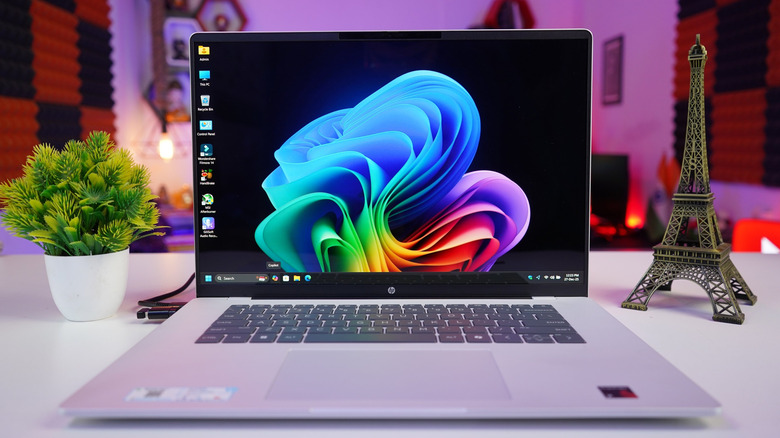 The HP OmniBook 5 laptop open on a table, showing the main desktop screen.