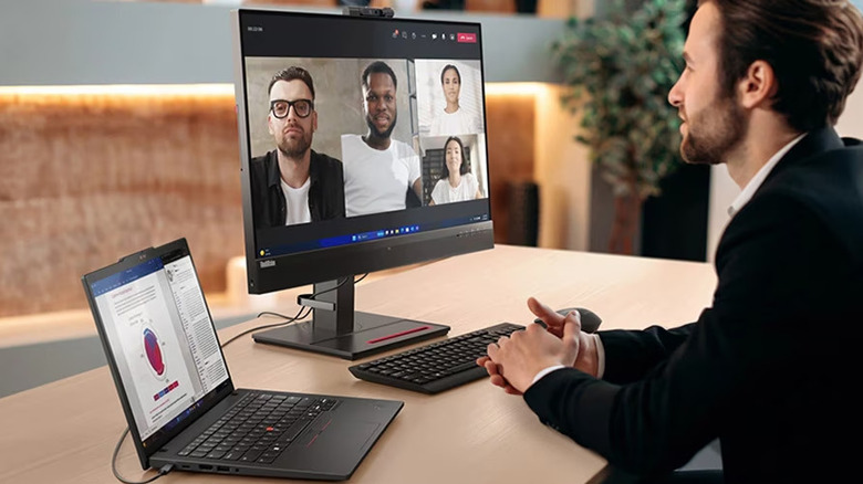 A Lenovo ThinkPad T14 Gen 6 laptop is connected to a monitor with a video call on display.