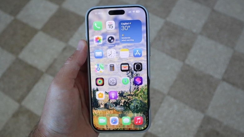 iPhone 16 Pro Max in hand, running iOS 26