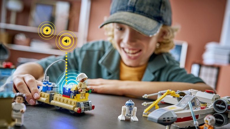 A child smiling while playing with a Lego Smart Play set.