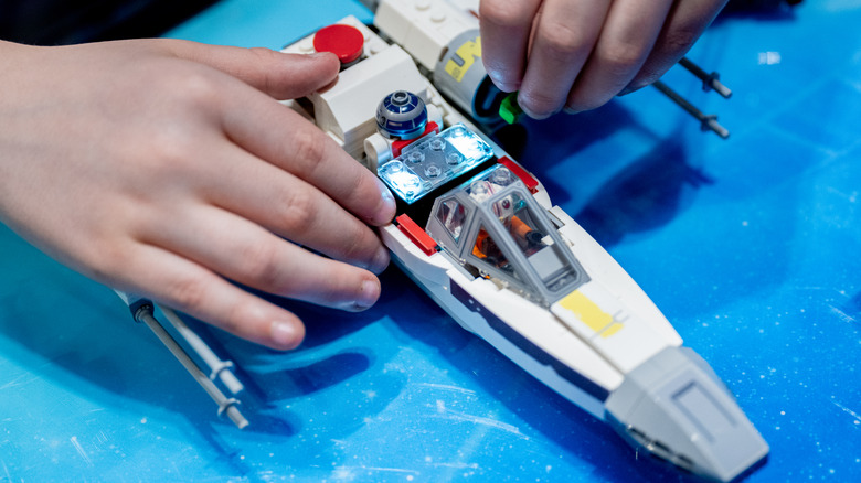 A Lego Smart Brick in use showing lights