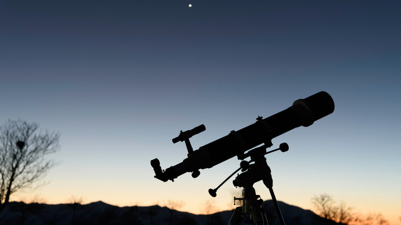 An astronomy telescope with a sunset backdrop