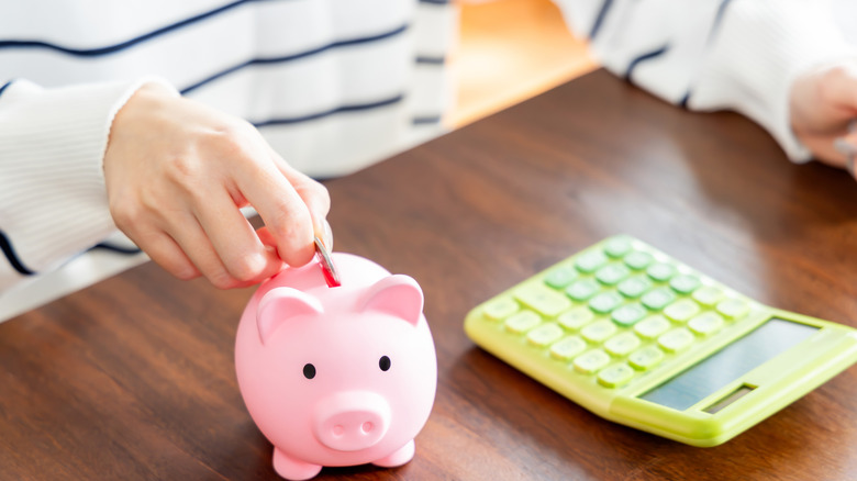An image representing saving money with a piggy bank and a yellow calculator