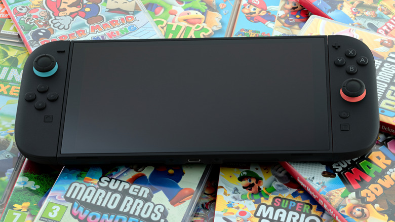 A black Nintendo Switch 2 sitting on top of a pile of games