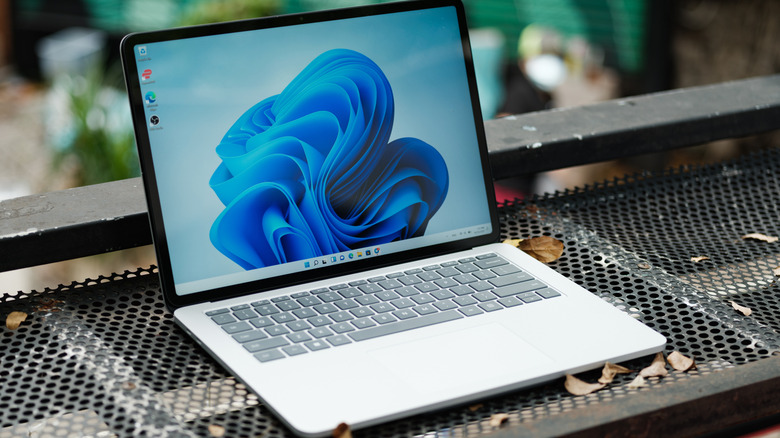 A laptop with Windows on a metal surface outside