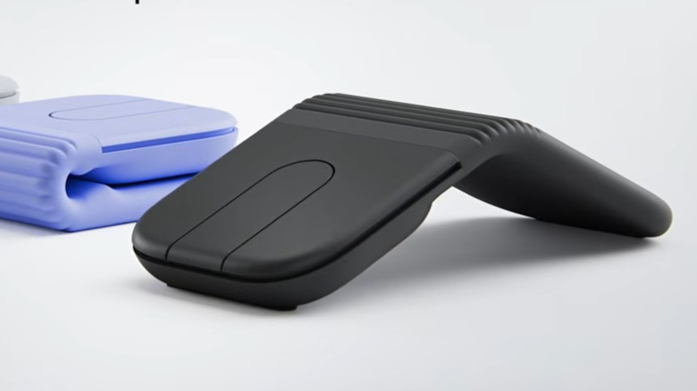 A Logitech Mobi Fold mouse in black on display with a blue mouse in the background