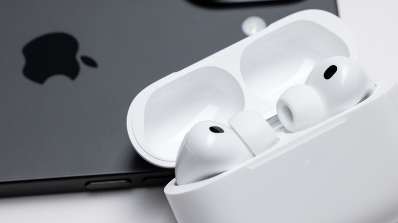 AirPods sitting on a table in their case on top of an iPhone