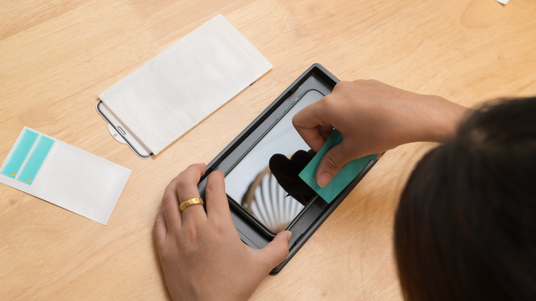 Someone installing a screen protector on their smartphone.