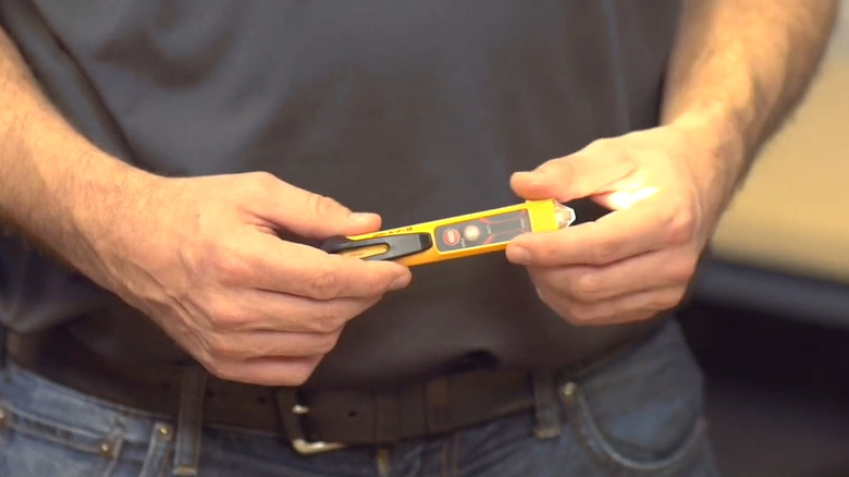 Man holding the Non-Contact Voltage while the front light is on