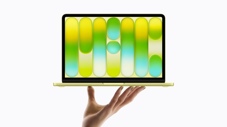 A hand holding the new MacBook Neo