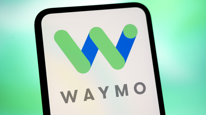 Waymo logo displayed on a smartphone screen with a blue and green gradient background