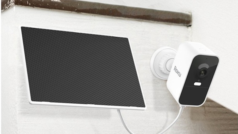 Roku battery camera plugged into solar panel outside a house