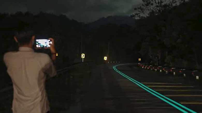 A man snaps a photo of Malaysia's photoluminescent road lines.