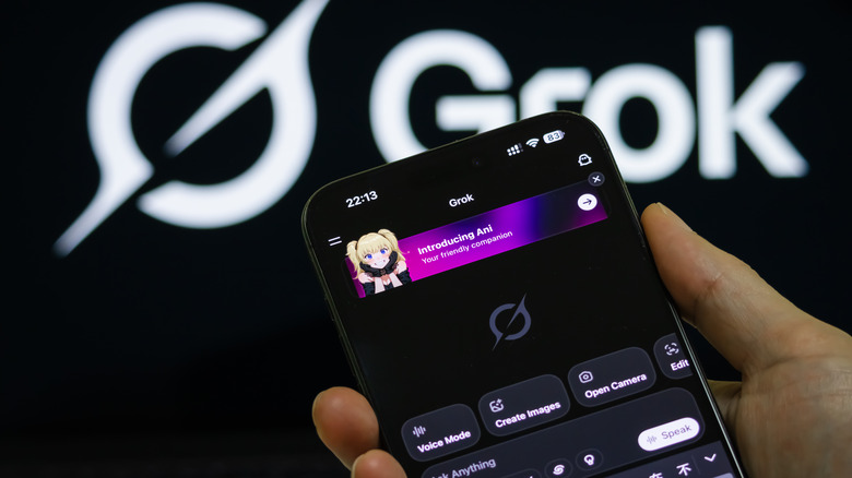 Hand holding smartphone with the Grok chatbot app open.