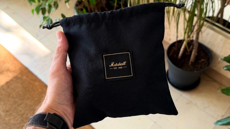 A hand holding Marshall's carrying case for its headphones