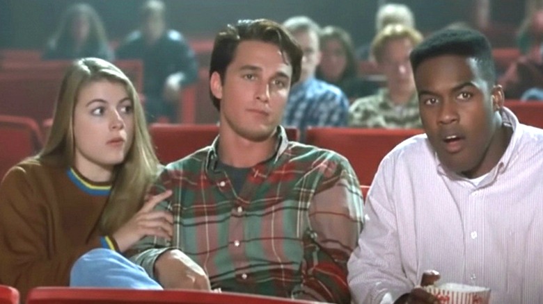 A theater-goer (Matthew McConaughey) sitting between two friends in 