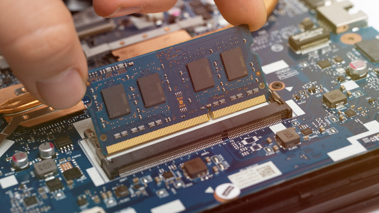 A stick of Ram DIMM being inserted into a motherboard