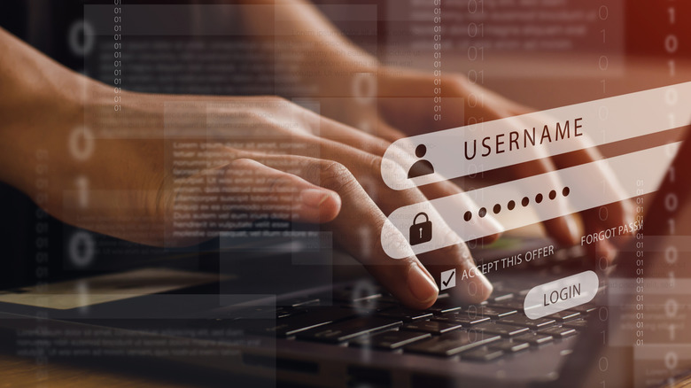 A person entering a user name and password on a laptop