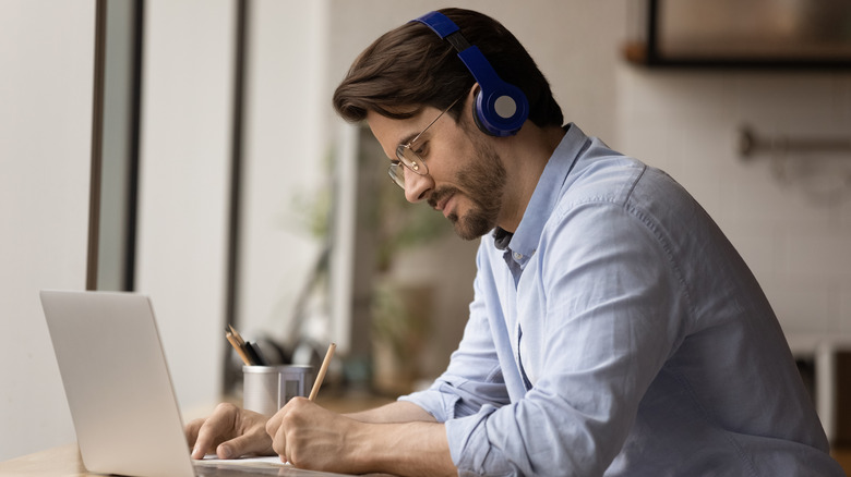 man using bluetooth headset with laptop