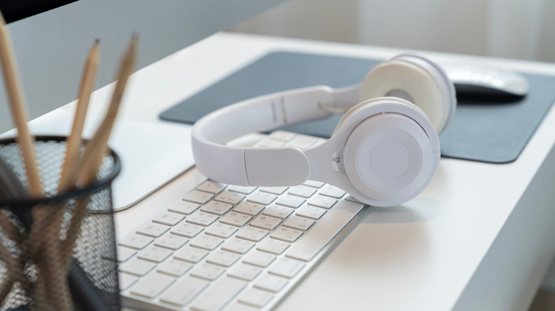 bluetooth headset laying across white keyboard