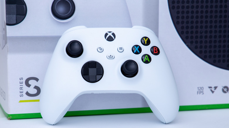 Microsoft xbox console box with controller in front of it